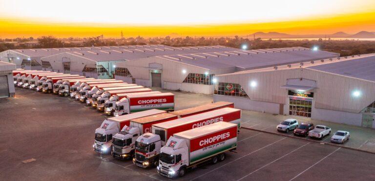 Choppies delivery trucks parked outside warehouse buildings